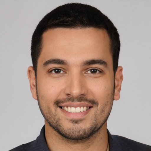 Joyful white young-adult male with short  black hair and brown eyes