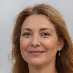 Joyful white adult female with long  brown hair and brown eyes