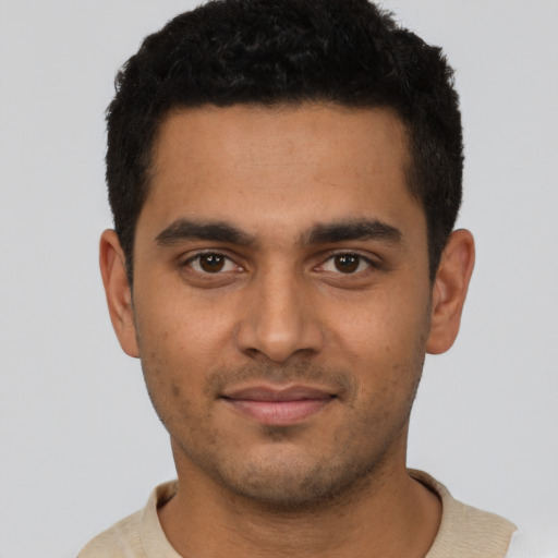 Joyful latino young-adult male with short  black hair and brown eyes