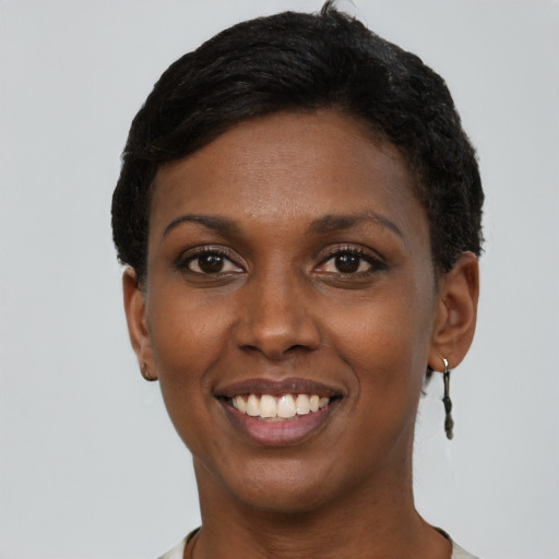 Joyful black young-adult female with short  black hair and brown eyes