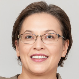 Joyful white adult female with medium  brown hair and grey eyes