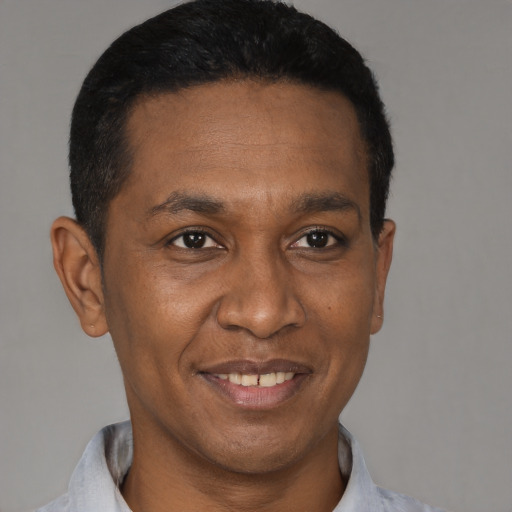 Joyful black adult male with short  black hair and brown eyes