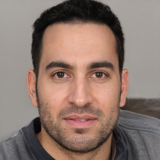 Joyful white young-adult male with short  black hair and brown eyes