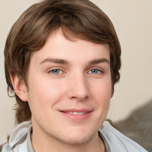 Joyful white young-adult male with medium  brown hair and grey eyes