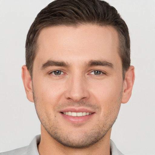 Joyful white young-adult male with short  brown hair and brown eyes