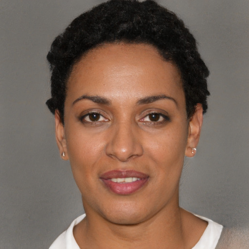 Joyful black young-adult female with short  black hair and brown eyes