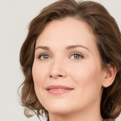 Joyful white young-adult female with medium  brown hair and green eyes