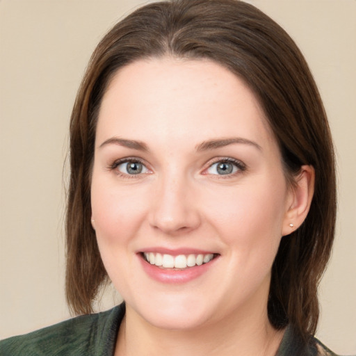 Joyful white young-adult female with medium  brown hair and green eyes