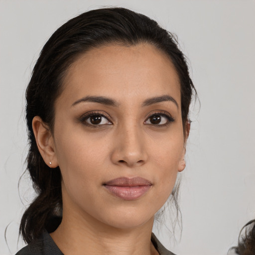 Joyful latino young-adult female with medium  black hair and brown eyes