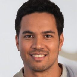 Joyful latino young-adult male with short  black hair and brown eyes
