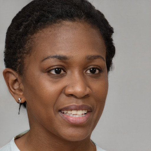 Joyful black young-adult female with short  brown hair and brown eyes