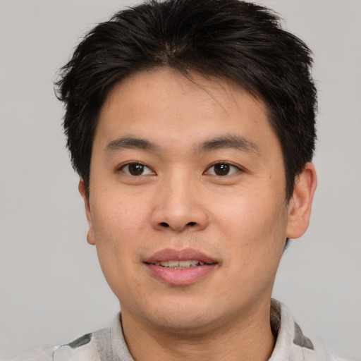 Joyful asian young-adult male with short  brown hair and brown eyes