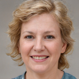 Joyful white young-adult female with medium  brown hair and blue eyes