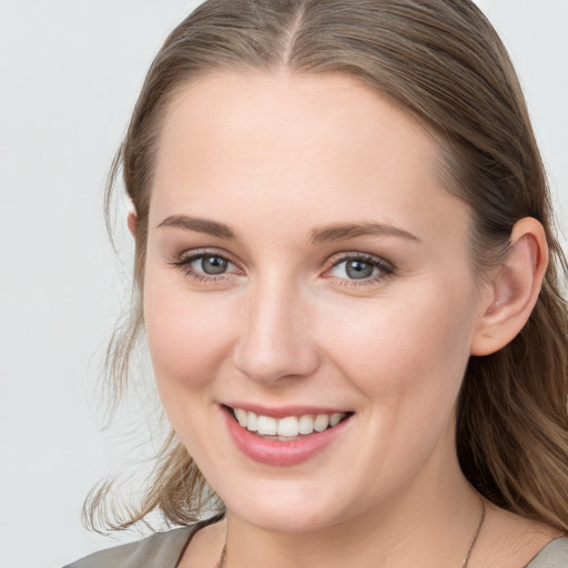 Joyful white young-adult female with long  brown hair and blue eyes