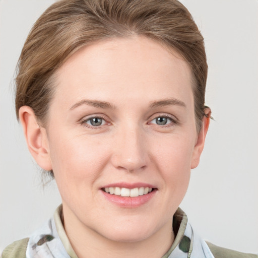 Joyful white young-adult female with medium  brown hair and grey eyes