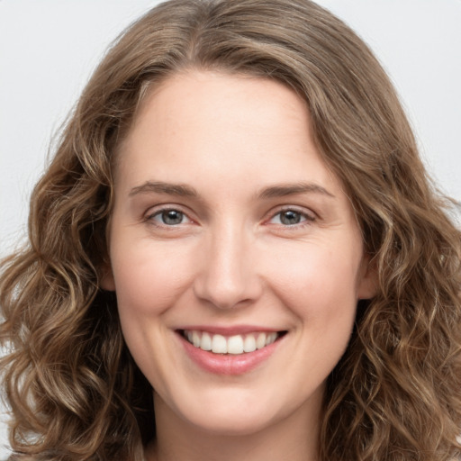 Joyful white young-adult female with long  brown hair and green eyes