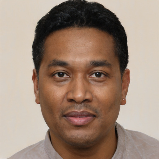 Joyful latino adult male with short  black hair and brown eyes