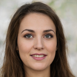 Joyful white young-adult female with long  brown hair and green eyes