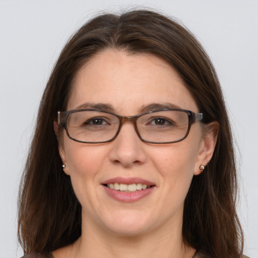 Joyful white adult female with long  brown hair and grey eyes