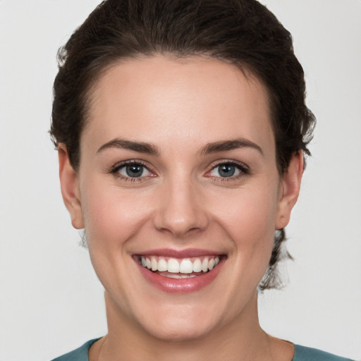 Joyful white young-adult female with short  brown hair and grey eyes