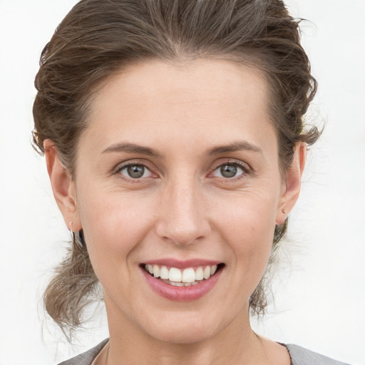 Joyful white young-adult female with medium  brown hair and grey eyes