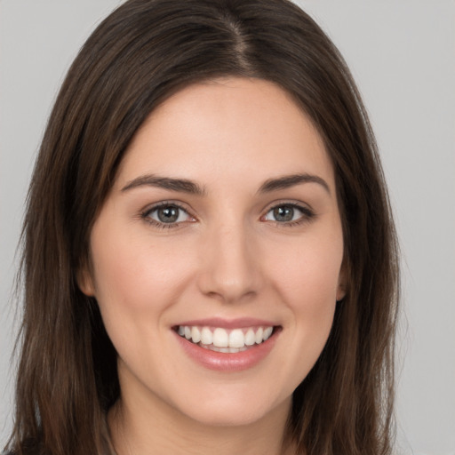 Joyful white young-adult female with long  brown hair and brown eyes