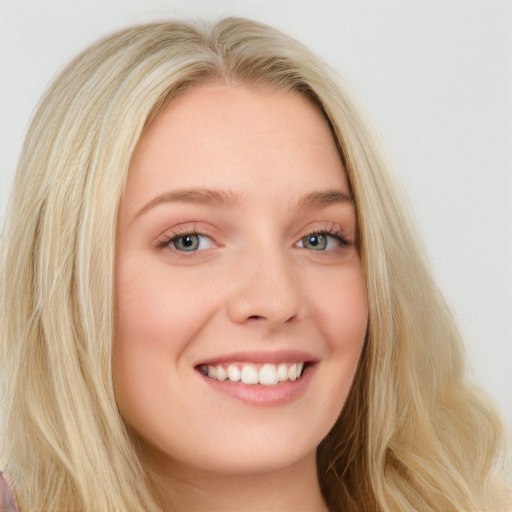 Joyful white young-adult female with long  blond hair and blue eyes