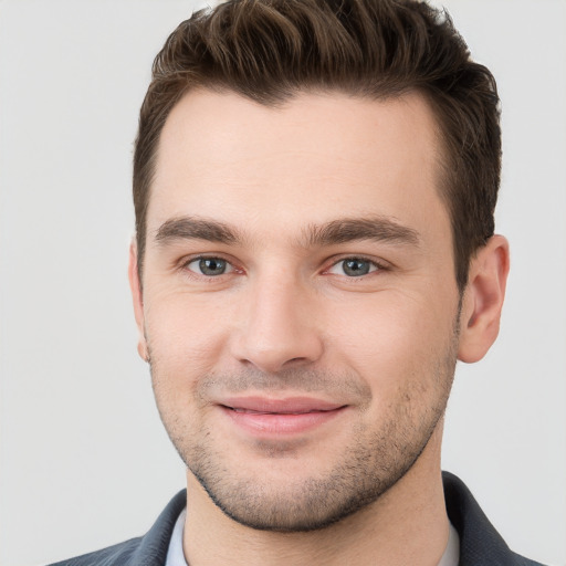 Joyful white young-adult male with short  brown hair and grey eyes