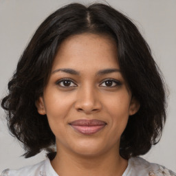 Joyful black young-adult female with medium  brown hair and brown eyes