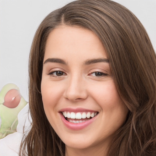 Joyful white young-adult female with long  brown hair and brown eyes