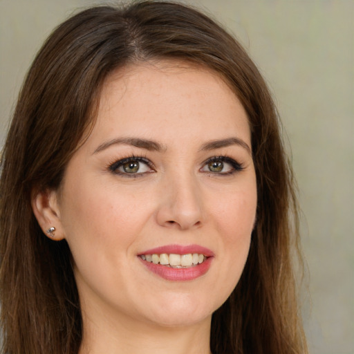 Joyful white young-adult female with long  brown hair and green eyes
