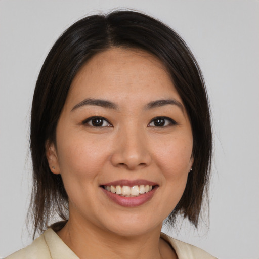 Joyful latino young-adult female with medium  brown hair and brown eyes