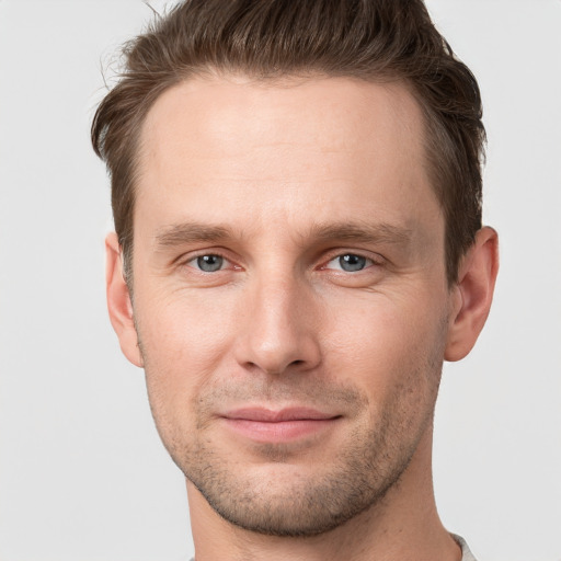 Joyful white young-adult male with short  brown hair and grey eyes