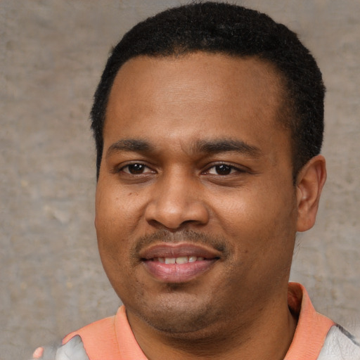 Joyful black young-adult male with short  black hair and brown eyes