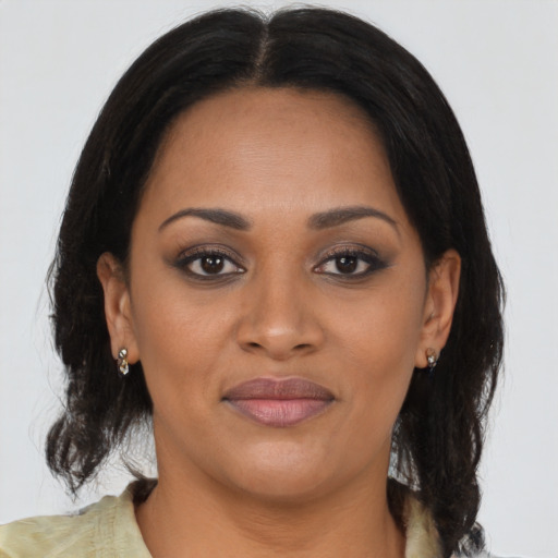 Joyful black young-adult female with medium  brown hair and brown eyes