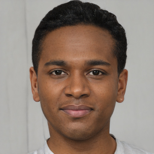 Joyful black young-adult male with short  black hair and brown eyes