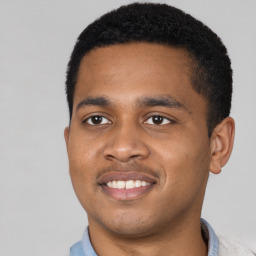 Joyful black young-adult male with short  black hair and brown eyes