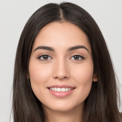 Joyful white young-adult female with long  brown hair and brown eyes