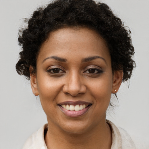 Joyful black young-adult female with short  brown hair and brown eyes