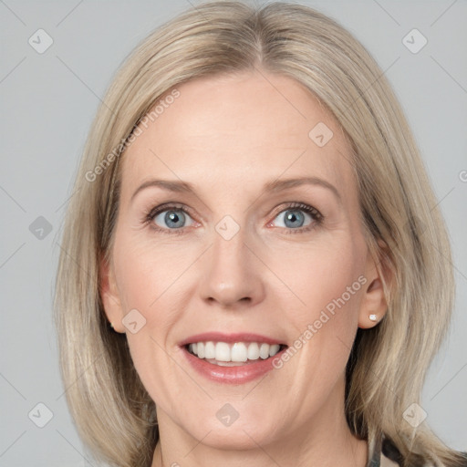 Joyful white adult female with medium  brown hair and blue eyes