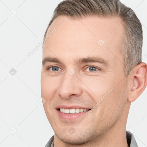 Joyful white young-adult male with short  brown hair and grey eyes