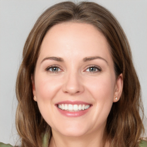 Joyful white young-adult female with long  brown hair and green eyes