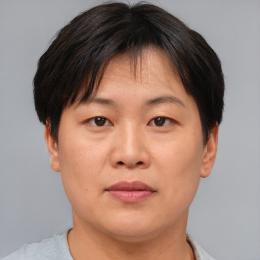 Joyful asian adult female with short  brown hair and brown eyes