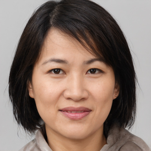 Joyful white adult female with medium  brown hair and brown eyes