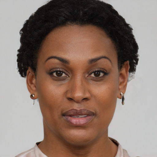 Joyful black adult female with short  brown hair and brown eyes