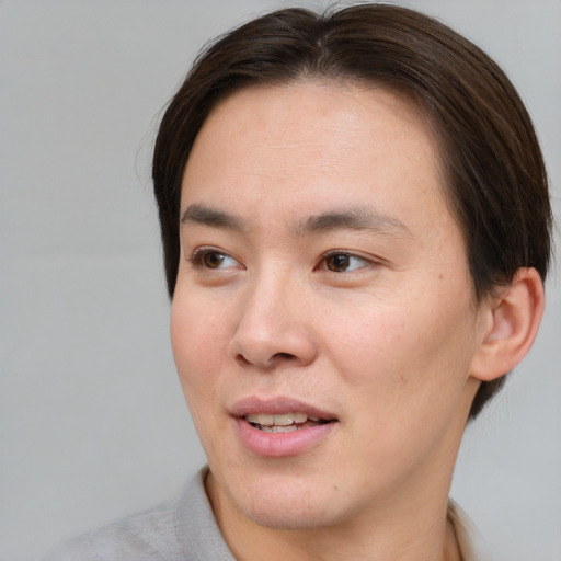 Joyful asian young-adult male with short  brown hair and brown eyes