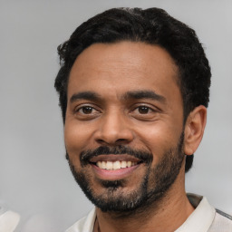 Joyful black young-adult male with short  black hair and brown eyes