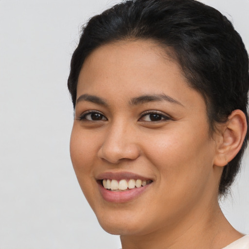 Joyful latino young-adult female with short  brown hair and brown eyes