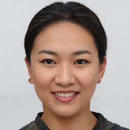 Joyful asian young-adult female with short  brown hair and brown eyes