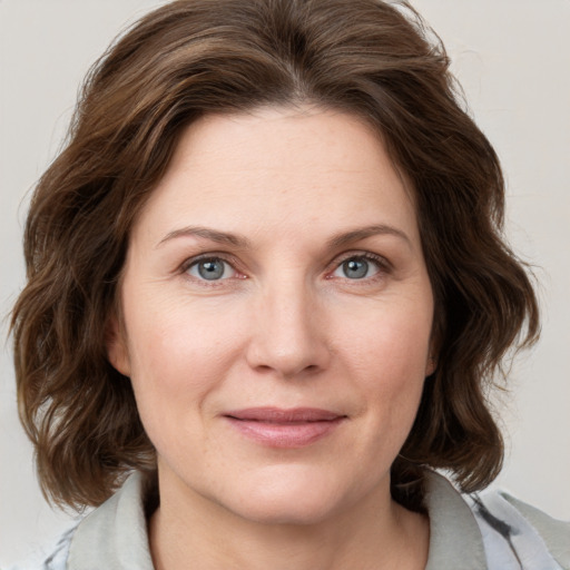 Joyful white young-adult female with medium  brown hair and blue eyes